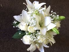 a bouquet of white flowers sitting on top of a carpeted floor next to a wall