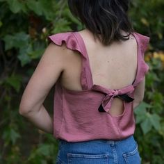 the back of a woman's pink top with a bow