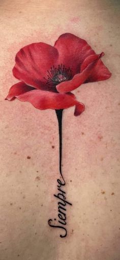 the back of a woman's neck with a red flower and words on it