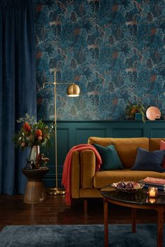 a living room filled with furniture and wallpaper covered in blue florals on the walls