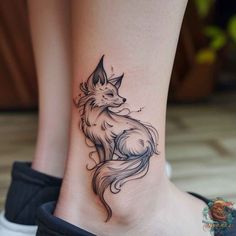 a small tattoo on the ankle of a woman's foot with an image of a fox