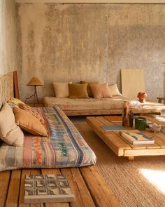 a living room filled with lots of furniture next to a wall covered in peeling paint