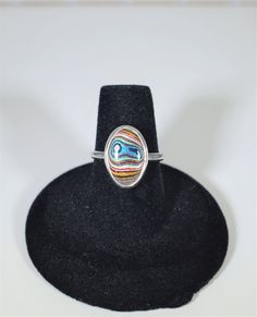 This listing is for one fordite silver ring. We crafted these fordite rings in solid fine and sterling silver. The bands are set size so that you can pick the one that is your size. These are size 6, 6.5, and 7 US. The fordite stones in these are about 14 x 10 mm. One of the frustrations with sized ring shopping is when you see a stone shape and color you like but it's not in your size. We kept that in mind while making these so that these stones are really all pretty similar. This is muscle car Oval Multicolor Rings With Inlay, Multicolor Oval Inlay Rings, Oval Multicolor Rings For Collectible, Oval Multicolor Rings For Collectors, Silver Oval Enamel Ring In Sterling Silver, Oval Silver Enamel Ring In Sterling Silver, Multicolor Polished Rings As A Gift, Multicolor Polished Finish Rings For Gift, Multicolor Polished Rings Perfect As Gift