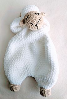 a crocheted stuffed animal laying on top of a white sheet