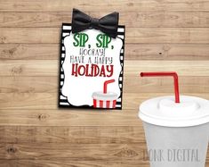 a coffee cup with a straw in it next to a sign that says sip, sip hooray have a happy holiday