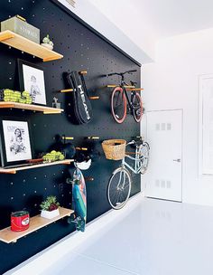 there is a bike on the wall next to some shelves with pictures and other items