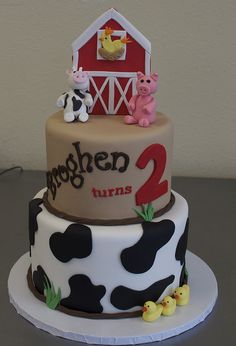 a birthday cake decorated with farm animals and the number two on it's side