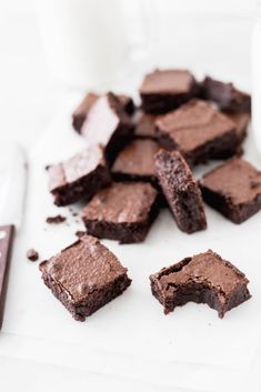 chocolate brownies cut in half on a cutting board next to a glass of milk