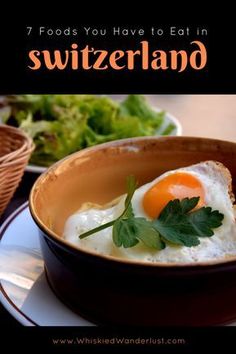 an egg in a bowl with parsley on top and the words 7 foods you have to eat in switzerland