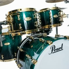 a green and gold drum set on top of a white background with the words pearl