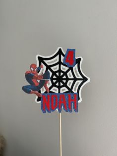 a spiderman cake topper with the name noah on it's center piece