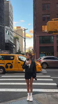 a woman standing in the middle of a cross walk