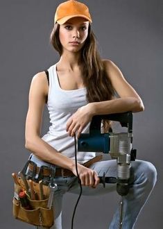 a woman is holding a driller and some tools