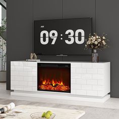 a white entertainment center with an electric fireplace and large clock on the wall above it