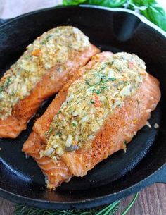 two cooked salmon fillets in a skillet