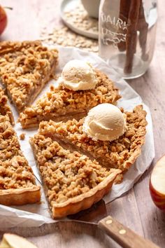 an apple pie with ice cream on top is cut into slices and sits on a table