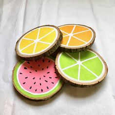 four slices of watermelon and orange on wood slices