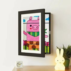 a painting of a pig hanging on the wall next to a clock and toy rabbit