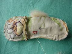 an old doll's hand made head and foot is laying on a green surface