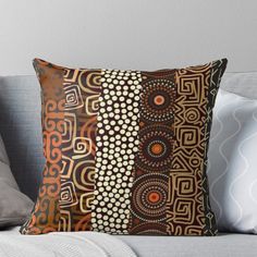 an orange and brown throw pillow sitting on top of a couch