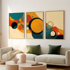 three abstract paintings hang on the wall above a white couch in a modern living room