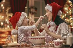 two women in santa hats are eating together