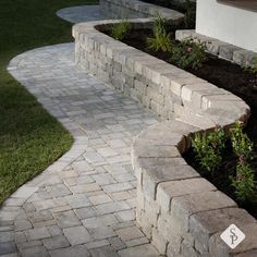 a stone bench sitting in the middle of a garden next to a flower bed and grass