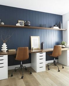 an office with two desks and shelves on the wall above them, along with chairs