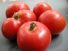 four tomatoes sitting on top of a table