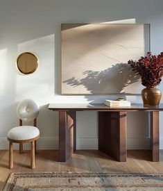 a table and chair in a room with a rug on the floor next to it