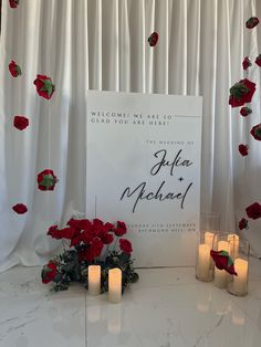 candles and flowers are placed next to a sign