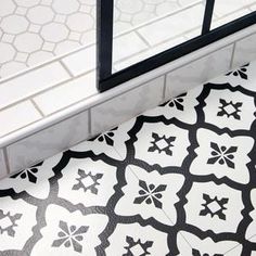 a black and white tiled floor next to a window