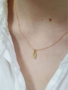 * An elegant 14K gold filled 6 x 15 mm leaf pendant on a super dainty cable chain. * Great for  layering for daytime or evening wear.  * Shown on the model in the 16 inch chain length. * Sold as a single chain * Available from 14 inch to 20 inch CURVED COLLAR necklace available separately in my shop: https://www.etsy.com/uk/listing/547199986/gold-curved-bar-necklace PACKAGING ::  Stylish branded packaging ::  Ready for giving, as shown in the last photo. ::  With a Linda Tucker Jewellery Photoca Everyday Gold Leaf-shaped Jewelry, Everyday Gold Leaf Jewelry, Choker Simple, Gold Leaf Necklace, Minimal Gold, Necklace Packaging, Necklace Simple, Gold Choker, Layering Necklace