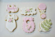 decorated cookies are arranged in the shape of baby's bibs and booties