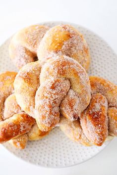 powdered sugar covered donuts on a white plate