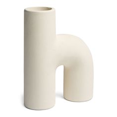 a white vase sitting on top of a table next to a tall tube shaped object