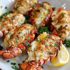 cooked lobsters on a plate with lemon wedges and parsley garnish