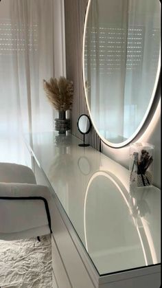 a white vanity with a round mirror on it