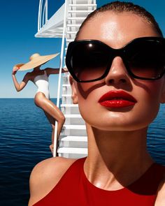 a woman wearing sunglasses standing next to a boat