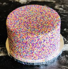 a cake with sprinkles on it sitting on a table