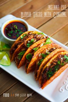 some tacos on a white plate with sauce and cilantro