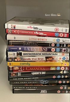 a stack of movies sitting on top of a shelf