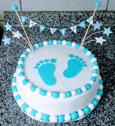 a blue and white cake with baby footprints on it