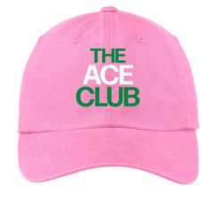 the ace club hat in pink with green lettering on it, against a white background