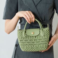 a woman holding a green handbag in her hands