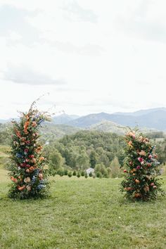 two tall floral arrangements in the middle of a field