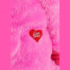 a pink teddy bear with a red heart on it's chest that says care bears