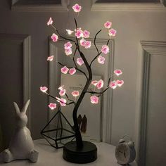 a lighted tree with pink flowers on it