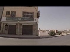 an empty street in front of a building with shutters on the doors and windows