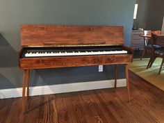 a wooden piano sitting on top of a hard wood floor